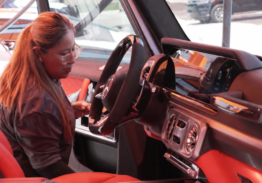 A NXTLVL team member cleaning the interior of a Mercedes G-Wagon